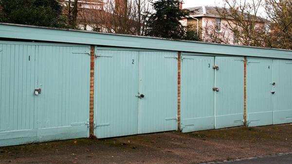 A housing developments block of garages with blue wooden doors